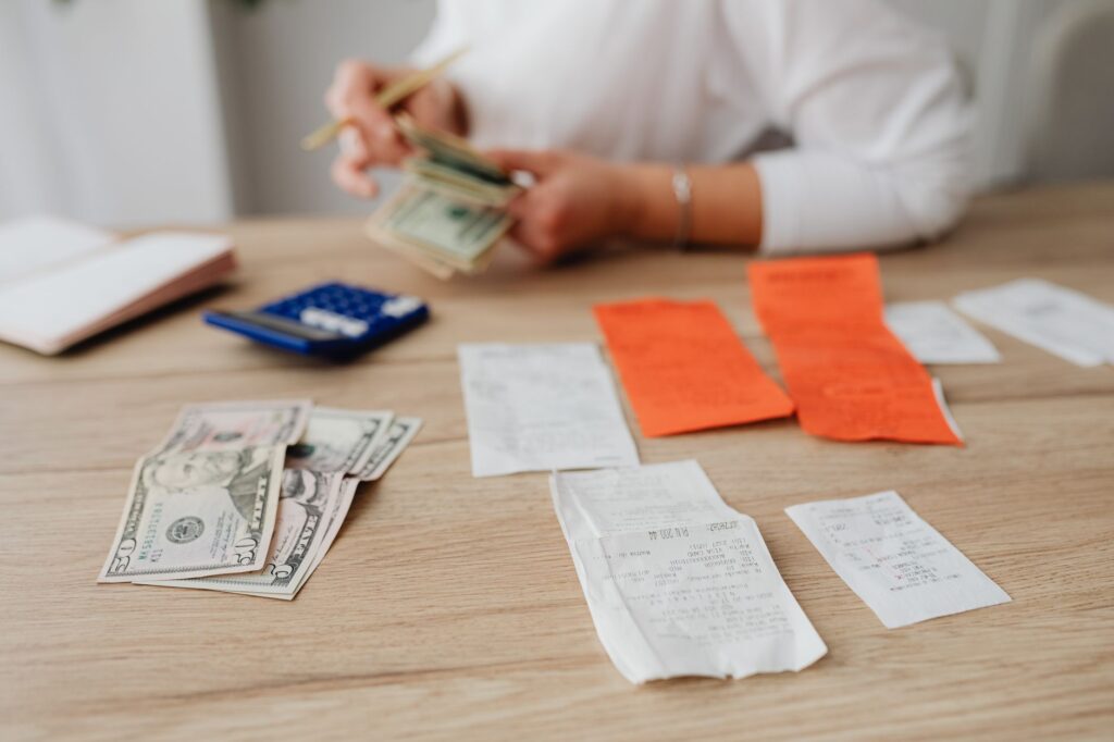 Person organising household income and expenses in a monthly budget notebook