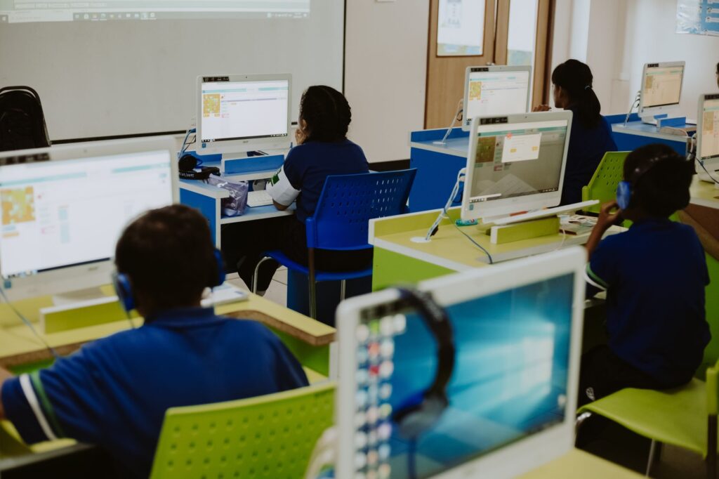 Adult newcomers practising computer skills together in a community classroom