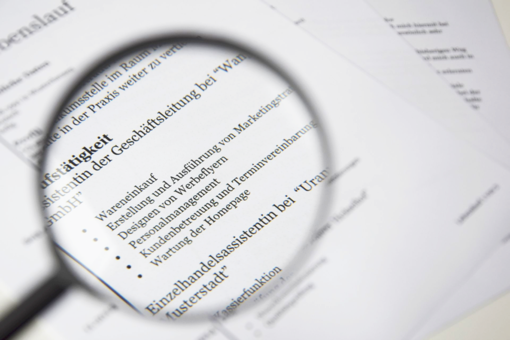 Job seeker comparing a resume with a job posting on a laptop